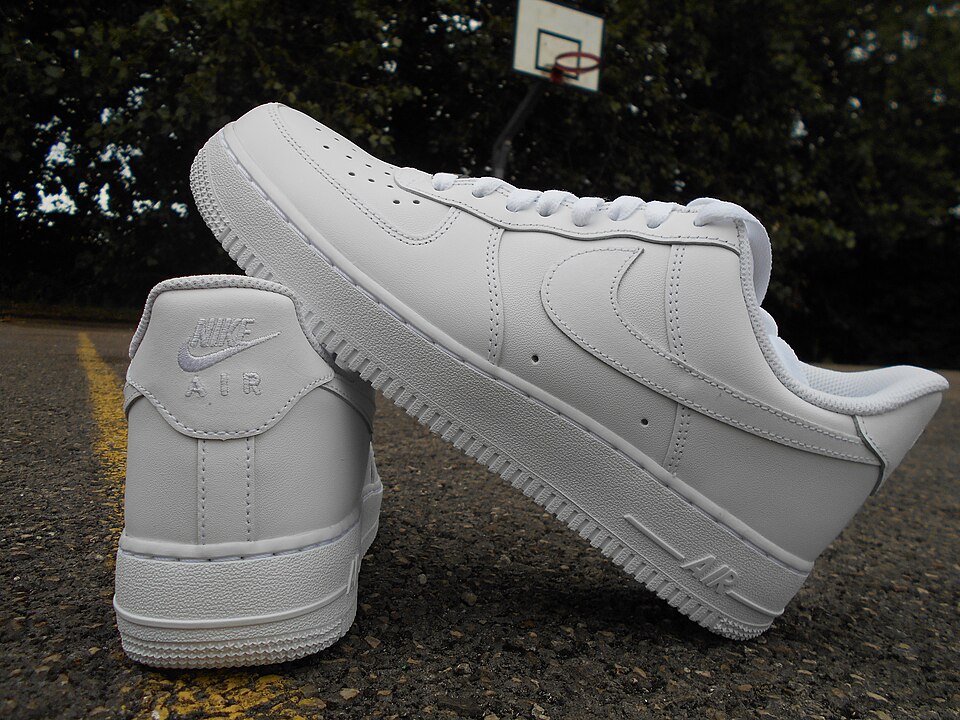 White Nike Air Force 1 sneakers photographed on pavement