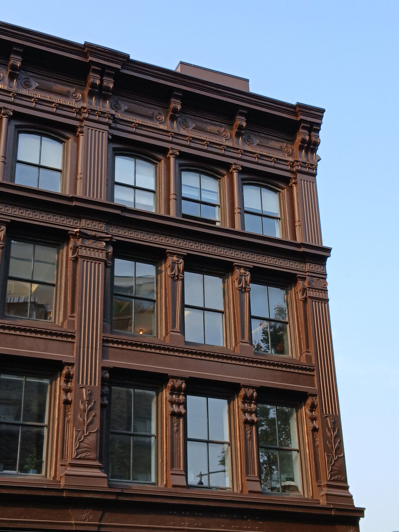 Ornate brown facade at 183 to 195 Broadway in Williamsburg against a blue sky