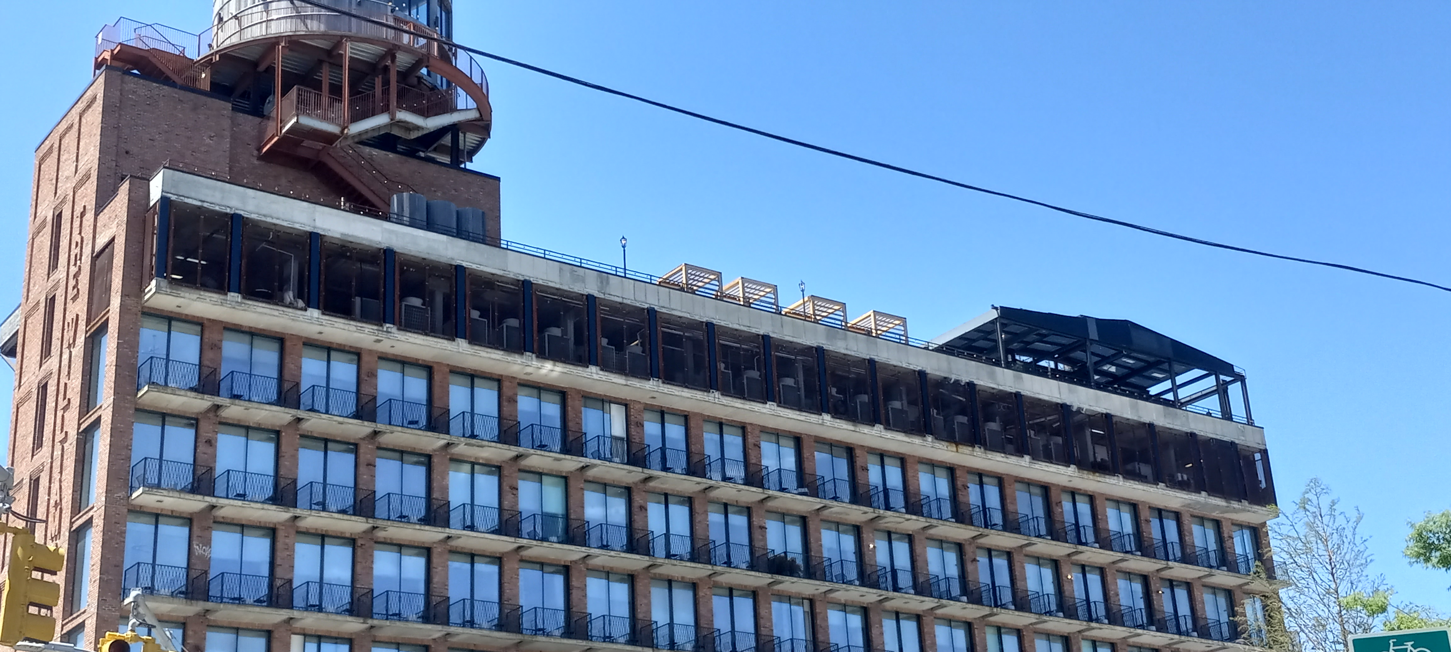 Brick facade, balconies and rooftop water tower at Arlo Williamsburg on Wythe Avenue