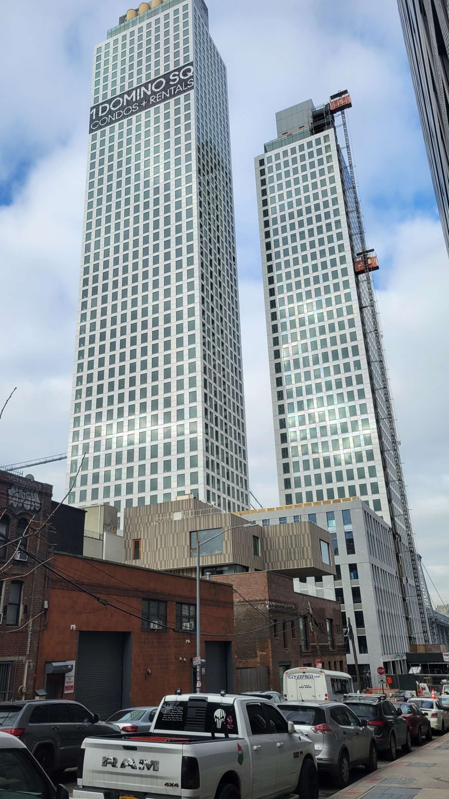 One Domino Square’s two pale porcelain clad towers under construction above Kent Avenue in February 2024